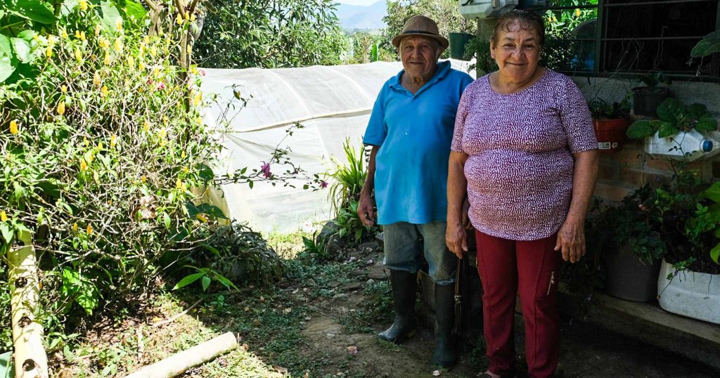 Ein Mann und Frau aus Kolumbien stehen in ihrem Garten.